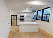 Thumbnail 48 of 53 - A kitchen with white cabinets and a white island.