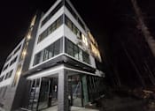 Thumbnail 19 of 53 - A modern building with a black and white facade is illuminated at night.