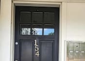 Thumbnail 4 of 24 - A black door with the number 154 on it.