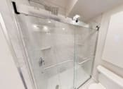 Thumbnail 18 of 24 - A white bathroom with a glass shower stall.