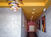 Thumbnail 10 of 12 - A hallway with a yellow ceiling and a red door.