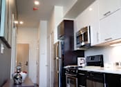 Thumbnail 7 of 12 - A kitchen with black appliances and white cabinets.