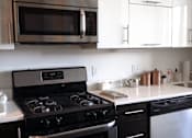 Thumbnail 8 of 12 - A black stove top oven with a digital display in the middle.