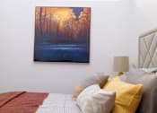 Thumbnail 9 of 12 - A bedroom with a bed, pillows and a painting on the wall.