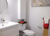 Thumbnail 12 of 12 - A white bathroom with a toilet, sink, and mirror.