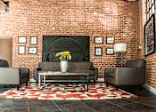 Thumbnail 12 of 12 - A living room with a brick wall and a fireplace.