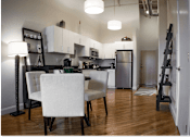 Thumbnail 3 of 12 - A kitchen with a dining table and chairs.