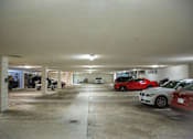 Thumbnail 4 of 12 - A parking garage with cars parked in it.