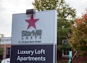 Thumbnail 11 of 12 - A sign for Starville Lofts is displayed in front of a tree.