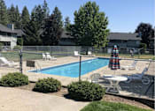 Thumbnail 4 of 7 - A pool surrounded by a fence and chairs.