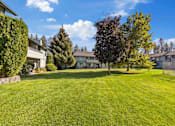 Thumbnail 5 of 7 - A large, well-maintained lawn in front of a row of houses.
