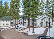 Thumbnail 5 of 18 - A white car is parked in a driveway in front of a house.