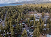 Thumbnail 1 of 18 - A forest of trees surrounds a small building.