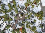 Thumbnail 8 of 18 - A bird's eye view of a snowy residential area with houses and trees.