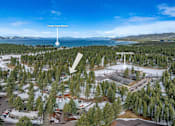 Thumbnail 10 of 18 - A snowy landscape with a lake and mountains in the background.