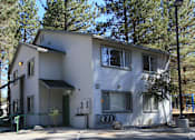 Thumbnail 3 of 18 - A two-story house with a white exterior and a green door.