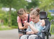 Thumbnail 16 of 19 - Disabled Child looking at flower with another child