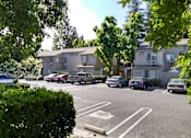 Thumbnail 17 of 19 - Colonial Farms Apartments - parking lot in front with apartment buildings in the background, trees