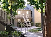Thumbnail 13 of 19 - Colonial Farms Apartments - concrete walkway up to stairs to apartments with tree in foreground