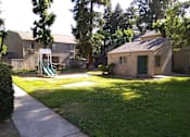 Thumbnail 12 of 19 - Colonial Farms Apartments - view of lawn and playground with apartment buildings in background