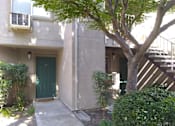 Thumbnail 5 of 19 - Colonial Farms Apartments - ground floor apartment entrance with concrete walkway up to door, with trees and bushes