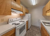Thumbnail 13 of 18 - A kitchen with a stove, refrigerator, and sink.