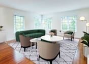 Thumbnail 4 of 14 - A living room with a green sofa and a white table.