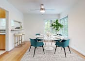 Thumbnail 5 of 14 - A dining room with a white table and blue chairs.