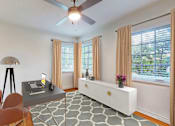 Thumbnail 6 of 14 - A room with a table, chairs, and a ceiling fan.