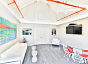 Thumbnail 14 of 19 - A living room with white furniture and a painting on the wall.