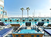 Thumbnail 16 of 34 - A pool area with sun loungers and palm trees at Esprit Marina del Rey, 90292