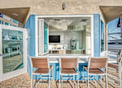 Thumbnail 6 of 8 - A dining table with chairs is set up outside a house.