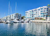Thumbnail 20 of 34 - A marina with boats and yachts in front of a white building at Esprit Marina del Rey, 90292