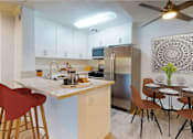 Thumbnail 4 of 23 - a kitchen with a breakfast bar and a stainless steel refrigerator at Casa Granada, Los Angeles, 90049