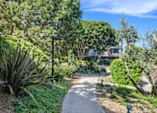 Thumbnail 16 of 16 - a path through a garden with trees and plants at Mariners Village, California, 90292