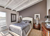 Thumbnail 12 of 14 - a bedroom with a bed and a painting on the wall at Mediterranean Village Costa Mesa, Costa Mesa, CA, 92626