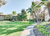 Thumbnail 5 of 14 - a yard with palm trees and a sidewalk at Mediterranean Village Costa Mesa, Costa Mesa