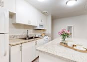 Thumbnail 11 of 23 - a kitchen with white cabinets and granite counter tops at Casa Granada, Los Angeles, CA