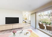 Thumbnail 3 of 15 - Two Bedroom Plan A - living room, balcony, and dining area at West Park Village Apartment Homes at West Park Village, Los Angeles, California