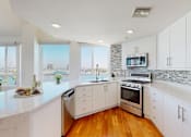 Thumbnail 3 of 34 - A modern kitchen with white cabinets and a marble countertop at Esprit Marina del Rey, 90292