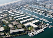 Thumbnail 7 of 19 - A marina with boats docked in the water and buildings surrounding it.