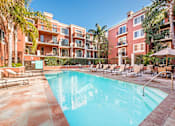 Thumbnail 22 of 24 - A swimming pool surrounded by lounge chairs and umbrellas in front of a red building at Marina Harbor, California, 90292
