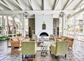 Thumbnail 2 of 14 - A living room with a fireplace and a white brick wall.