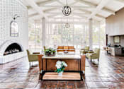 Thumbnail 3 of 14 - A living room with a fireplace and a dining table.