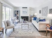 Thumbnail 6 of 14 - A living room with a fireplace and a couch.