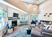 Thumbnail 2 of 16 - A living room with a fireplace and a television.