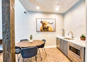 Thumbnail 16 of 16 - A kitchen with a table and chairs and a painting of a bison on the wall.