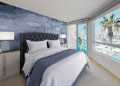 Thumbnail 15 of 34 - A bedroom with a large bed and a view of a marina at Esprit Marina del Rey, 90292
