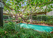 Thumbnail 8 of 15 - A pool surrounded by green plants and trees.
