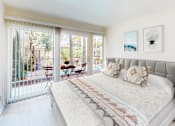 Thumbnail 4 of 18 - A bedroom with a large bed and a table outside at West Park Village, Los Angeles, CA
